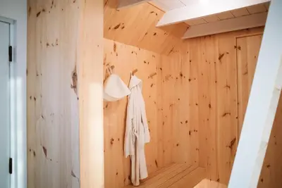 a dressing room with wood paneling and a dress hanging on a wall at Chez Pedro in Saint-Valère