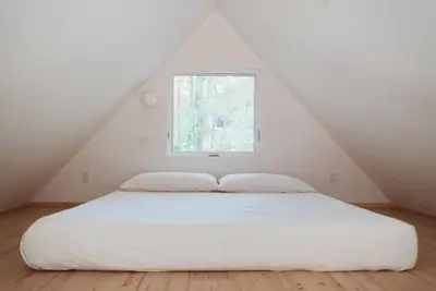 a white bed in a room with a window at Chez Pedro in Saint-Valère