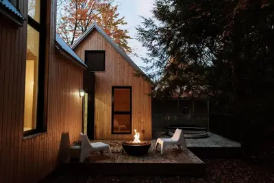 two white chairs and a fire pit in front of a house at Chez Pedro in Saint-Valère