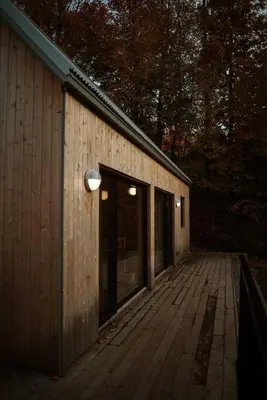a wooden deck with a building with a door at Chez Pedro in Saint-Valère