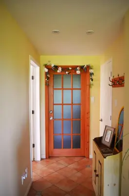 aoyer with a wooden door in a room at Suite-appartement 2 chambres à la campagne. Rez de jardin in Dunham