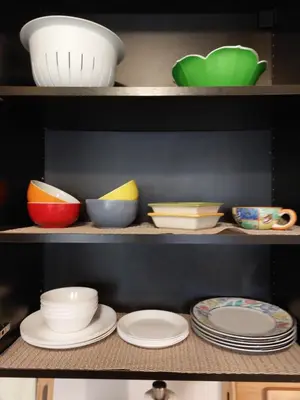 a shelf filled with plates and bowls on top at Appartement Cartier 2 in Longueuil