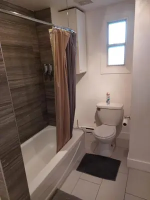 a bathroom with a tub and a toilet and a shower at Appartement Cartier 2 in Longueuil