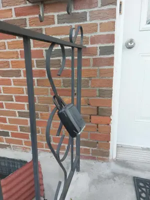 a black iron fence with a bag on it next to a door at Appartement Cartier 2 in Longueuil