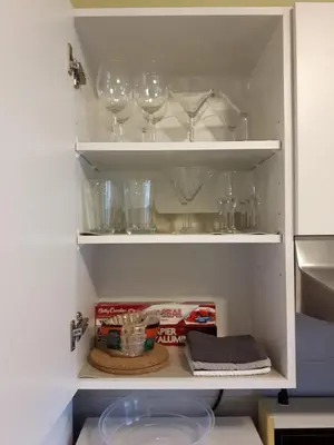 a cupboard with wine glasses and other items in it at Appartement Cartier in Longueuil