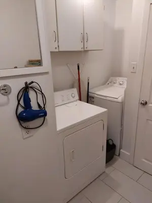 a white laundry room with a washer and dryer at Appartement Cartier in Longueuil