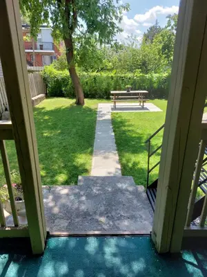 a view of a park with a bench and grass at Appartement Cartier in Longueuil
