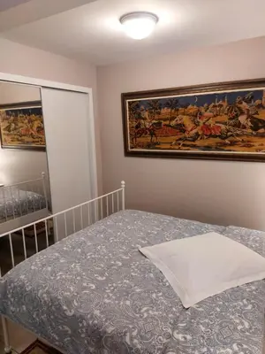 a bedroom with a bed and a painting on the wall at Appartement Cartier in Longueuil