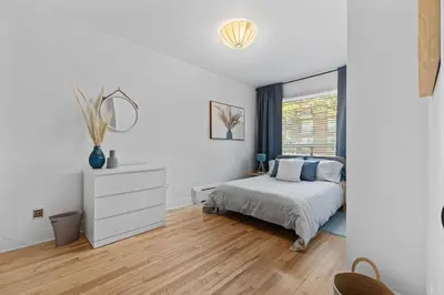 a white bedroom with a bed and a window at Large Beautiful 2BR Apartment fully equipped in Montréal