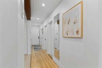 a hallway with white walls and a framed picture on the wall at Large Beautiful 2BR Apartment fully equipped in Montréal