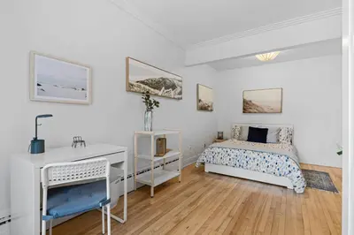 a white bedroom with a bed and a desk at Large Beautiful 2BR Apartment fully equipped in Montréal