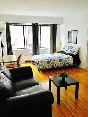 a living room with a bed and a couch at Stylish Montreal Apartment: Comfortable Stay in the Golden Square Mile in Montréal