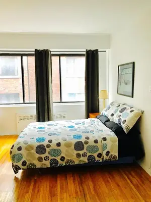 a bedroom with a bed and two windows at Stylish Montreal Apartment: Comfortable Stay in the Golden Square Mile in Montréal