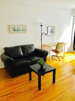 a living room with a black couch and a table at Stylish Montreal Apartment: Comfortable Stay in the Golden Square Mile in Montréal