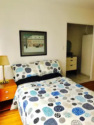a bedroom with a bed with a blue and white comforter at Stylish Montreal Apartment: Comfortable Stay in the Golden Square Mile in Montréal