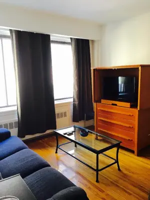 a living room with a couch and a tv at Stylish Montreal Apartment: Comfortable Stay in the Golden Square Mile in Montréal