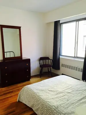 a bedroom with a bed and a dresser and a mirror at Stylish Montreal Apartment: Comfortable Stay in the Golden Square Mile in Montréal