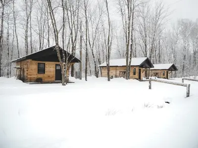a log cabin in the woods in the snow at Camping Abenaki Aventure - Les Chalets in Pierreville