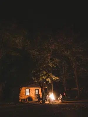 a house with a light in front of it at night at Camping Abenaki Aventure - Les Chalets in Pierreville