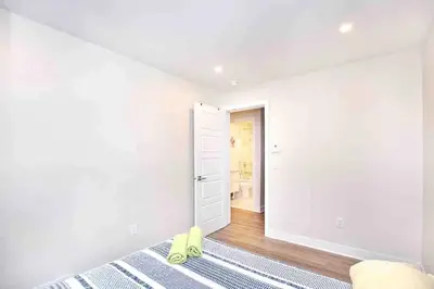 a bedroom with white walls and a bed and a door at Beautiful 4-BDR in Heart of Plateau Mont-Royal in Montréal
