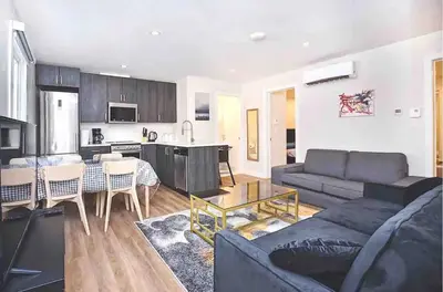 a living room with a couch and a table and a kitchen at Beautiful 4-BDR in Heart of Plateau Mont-Royal in Montréal