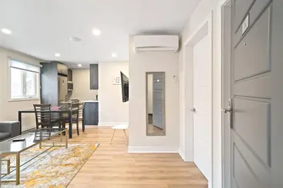 a living room with a table and chairs and a door at DUPLEX 6 BEDROOMS IN HEART OF PLATEAU MONT-ROYAL in Montréal