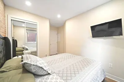a bedroom with a bed and a television on the wall at DUPLEX 6 BEDROOMS IN HEART OF PLATEAU MONT-ROYAL in Montréal