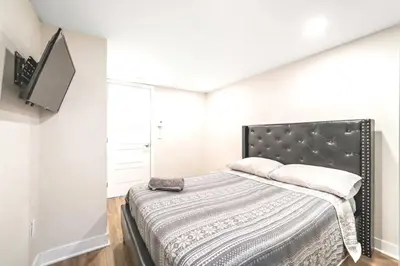 a bedroom with a bed and a flat screen tv at DUPLEX 6 BEDROOMS IN HEART OF PLATEAU MONT-ROYAL in Montréal