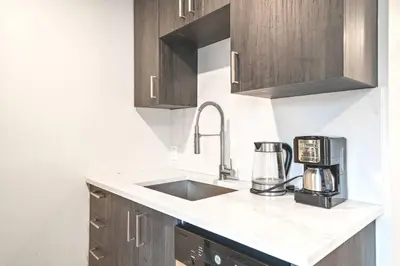 a kitchen with a sink and a coffee maker at DUPLEX 6 BEDROOMS IN HEART OF PLATEAU MONT-ROYAL in Montréal