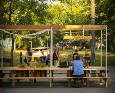 a group of people sitting at a picnic table in a park at Ideal Group Stay in Charming Le Plateau Near Metro in Montréal