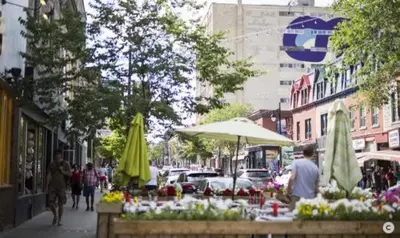 a street with a market with flowers and umbrellas at Ideal Group Stay in Charming Le Plateau Near Metro in Montréal
