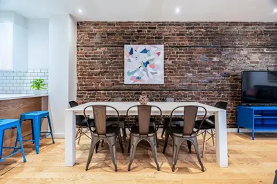 a dining room with a brick wall and a table and chairs at Ideal Group Stay in Charming Le Plateau Near Metro in Montréal