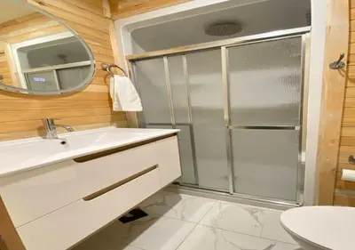 a bathroom with a shower and a sink and a mirror at chalet Ani in Piopolis