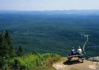 two people sitting on a bench on top of a mountain at chalet Ani in Piopolis