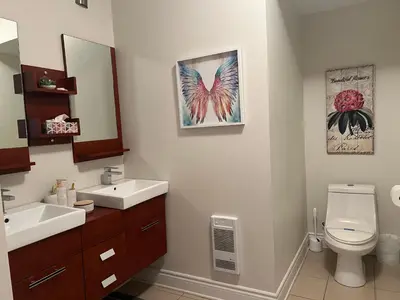 a bathroom with a sink and a toilet and a mirror at Superbe condo - Navette de Ski Gratuite #102 in Bromont