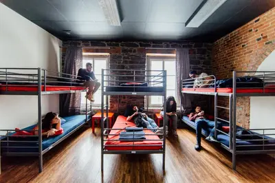 a group of people sitting on bunk beds in a room at Alt Hostel in Montréal