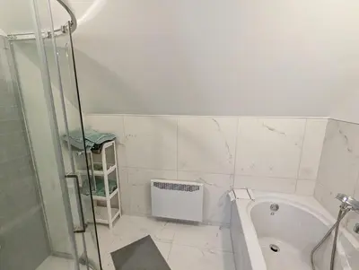 a bathroom with a shower and a tub and a sink at Impeccable, modern, river view, renovated cottage in Laval