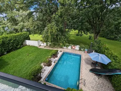 an overhead view of a swimming pool with an umbrella at Impeccable, modern, river view, renovated cottage in Laval