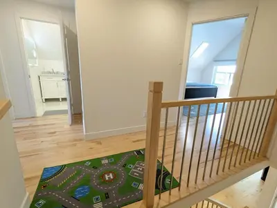 a staircase in a house with a rug at Impeccable, modern, river view, renovated cottage in Laval