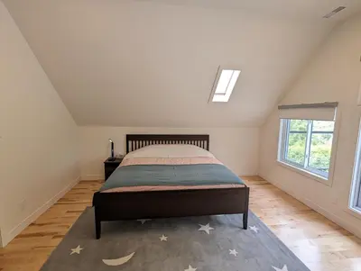 a bedroom with a bed with stars on the floor at Impeccable, modern, river view, renovated cottage in Laval