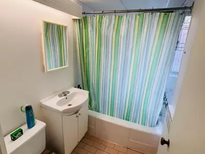 a bathroom with a sink and a shower curtain at Stylish Montreal Apartment: Comfortable Stay in the Golden Square Mile in Montréal