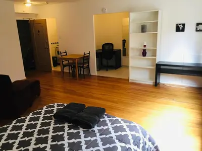 a room with a bed and a table and a piano at Stylish Montreal Apartment: Comfortable Stay in the Golden Square Mile in Montréal