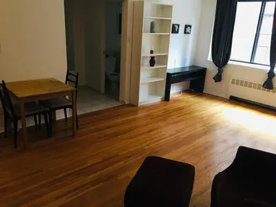 a living room with a wooden table and a desk at Stylish Montreal Apartment: Comfortable Stay in the Golden Square Mile in Montréal