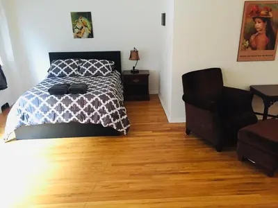 a bedroom with a bed and a chair at Stylish Montreal Apartment: Comfortable Stay in the Golden Square Mile in Montréal