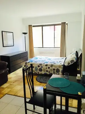 a bedroom with a bed and a table and a dining room at Stylish Montreal Apartment: Comfortable Stay in the Golden Square Mile in Montréal
