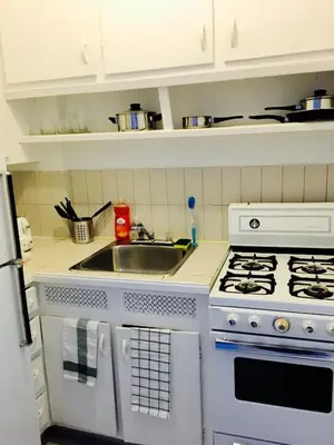 a kitchen with a white stove and a sink at Stylish Montreal Apartment: Comfortable Stay in the Golden Square Mile in Montréal