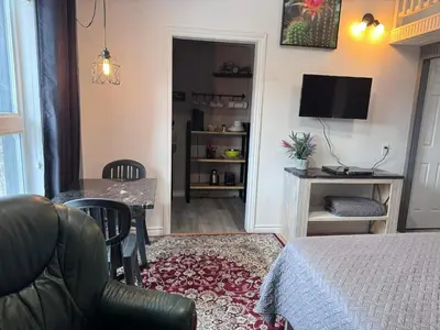 a bedroom with a bed and a table and a television at Le Studio CITQ3O1849 in Saint Pierre de Broughton
