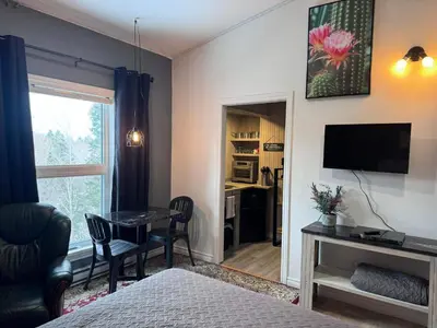 a room with a bed and a desk with a table at Le Studio CITQ3O1849 in Saint Pierre de Broughton