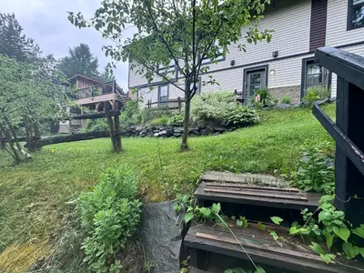 a house with a yard with a porch and a deck at Le Studio CITQ3O1849 in Saint Pierre de Broughton