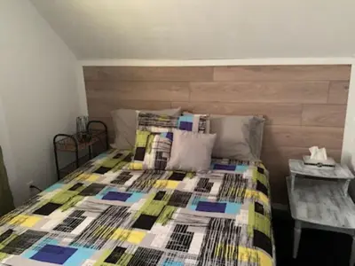a bedroom with a bed with a colorful quilt on it at Gîte des étoiles in Notre-Dame-Des-Bois